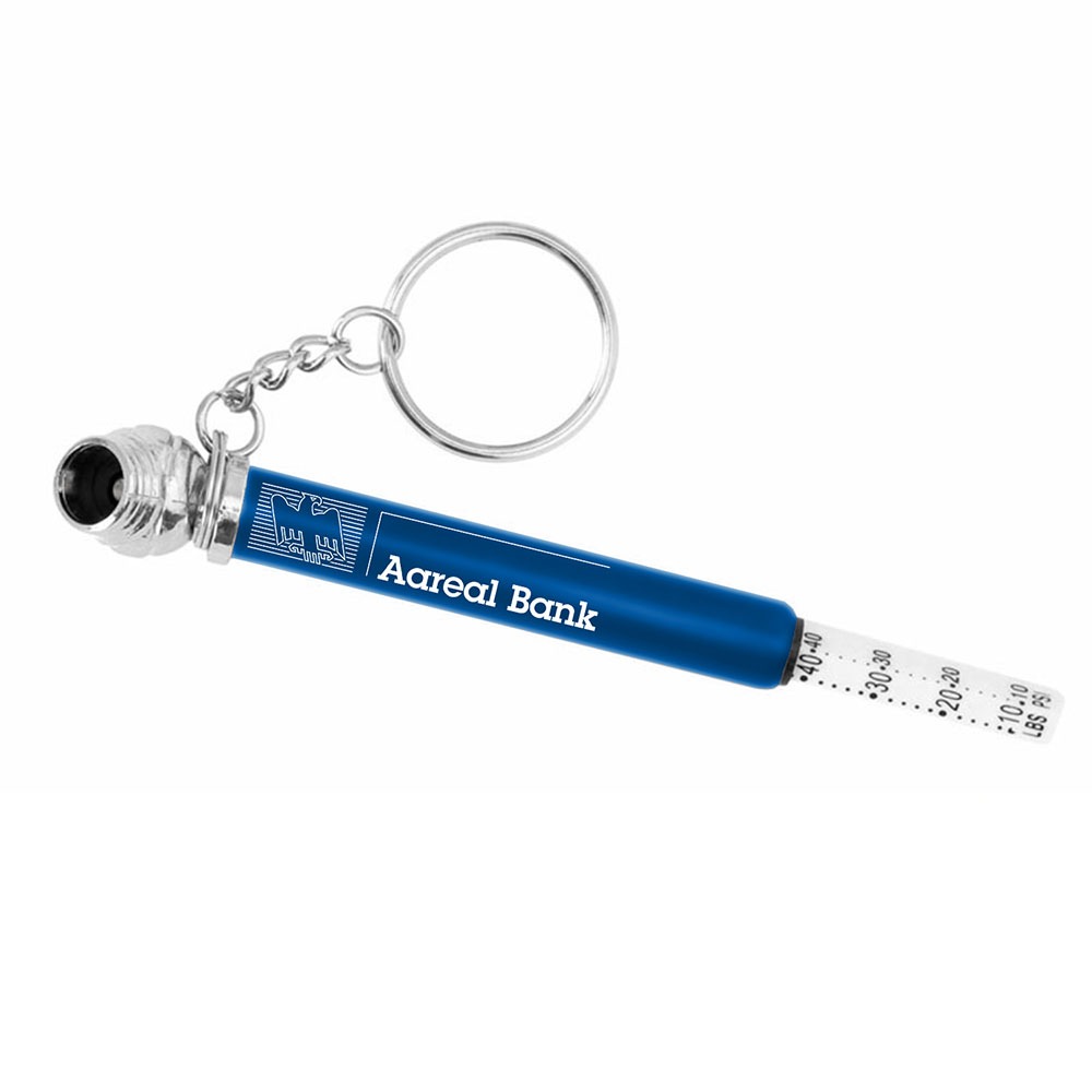 Ein blauer Vollblut Aareal Bank-Schlüsselanhänger mit einem Gebäudelogo, an dessen einem Ende ein Reifendruckmesser herausragt.
