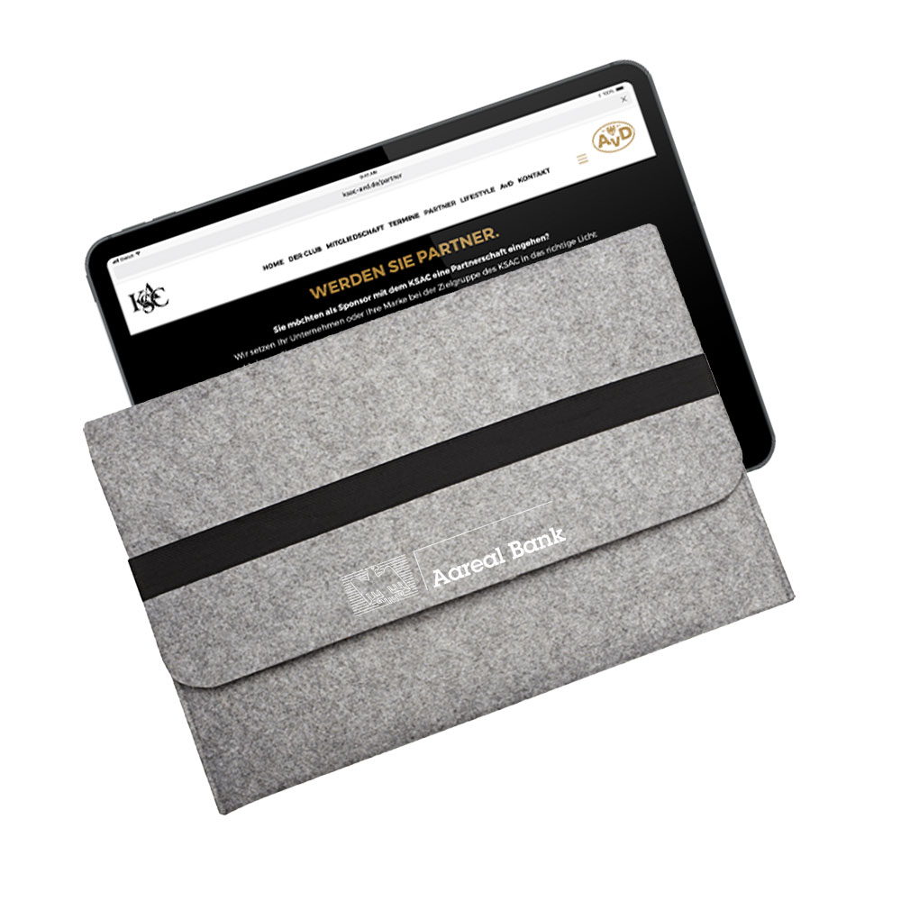 Ein Tablet, teilweise in einer grauen Filzhülle mit schwarzem Streifen und dem Aufdruck „Vollblut Aareal Bank“ auf der Vorderseite. Das Tablet zeigt eine Webseite auf Deutsch an.