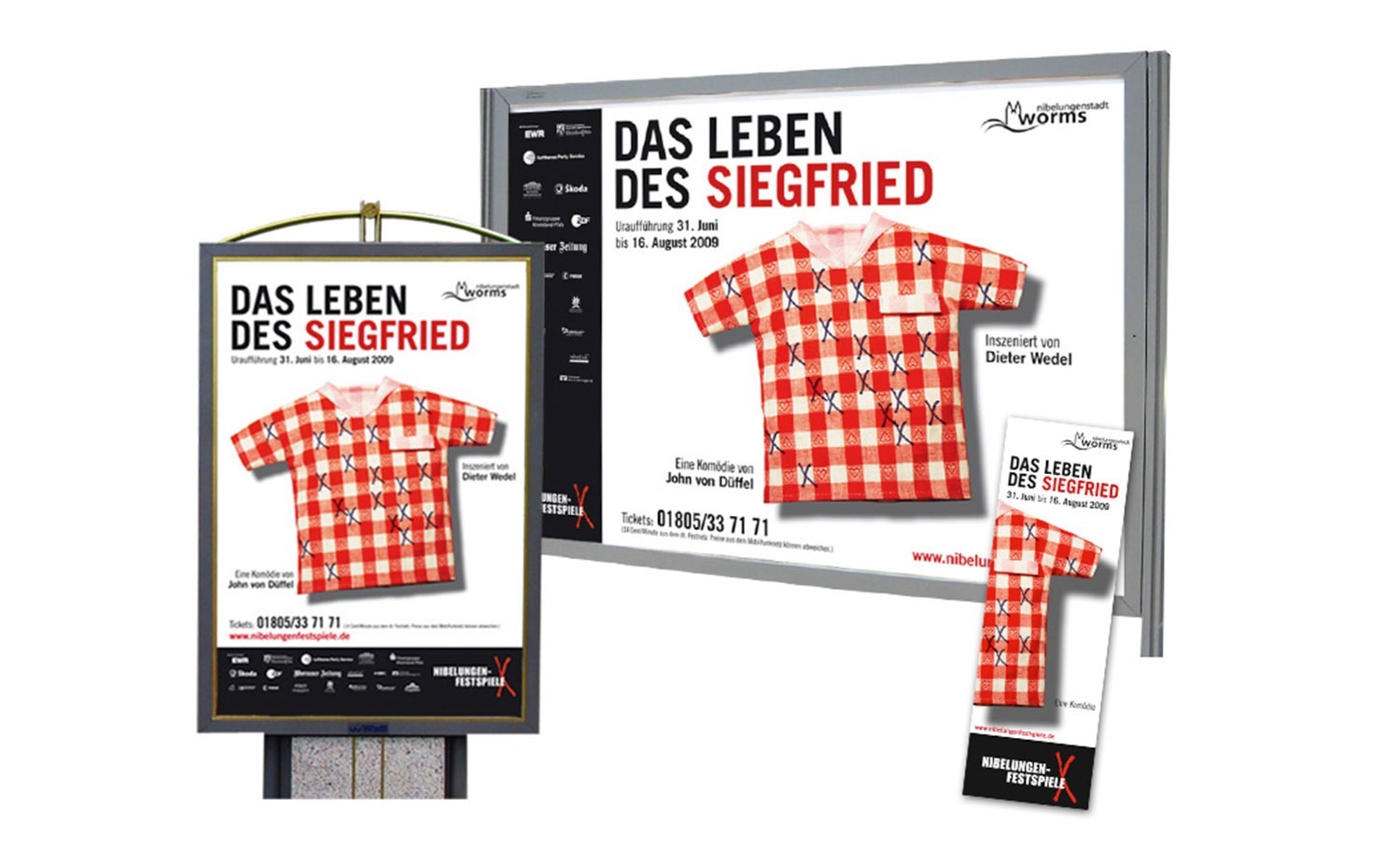 Eine Werbefläche mit Postern, einer Plakatwand und einem Flyer für „Das Leben des Siegfried“ bei den Vollblut Nibelungen Festspielen, jeweils mit einem rot-weiß karierten Hemd mit schwarzen Markierungen auf weißem Grund.
