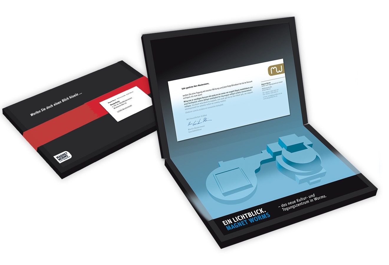 Eine offene schwarze Geschenkbox zeigt einen Buchstaben und blaue abstrakte Formen im Inneren. Daneben steht eine geschlossene passende Box mit rotem Streifen und dem Etikett „Vollblut Wormser“. Beide sind mit Logos und deutschem Text versehen.
