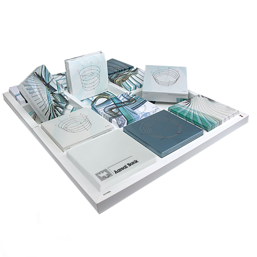 Eine Reihe von Büchern oder Notizbüchern mit abstrakten, geometrischen Einbanddesigns in Blau, Weiß und Grau – einige davon mit Spiral- oder Kreislinienmustern – sind auf einer weißen Plattform angeordnet und erinnern an die moderne Ästhetik, die man oft bei der Vollblut Aareal Bank sieht.