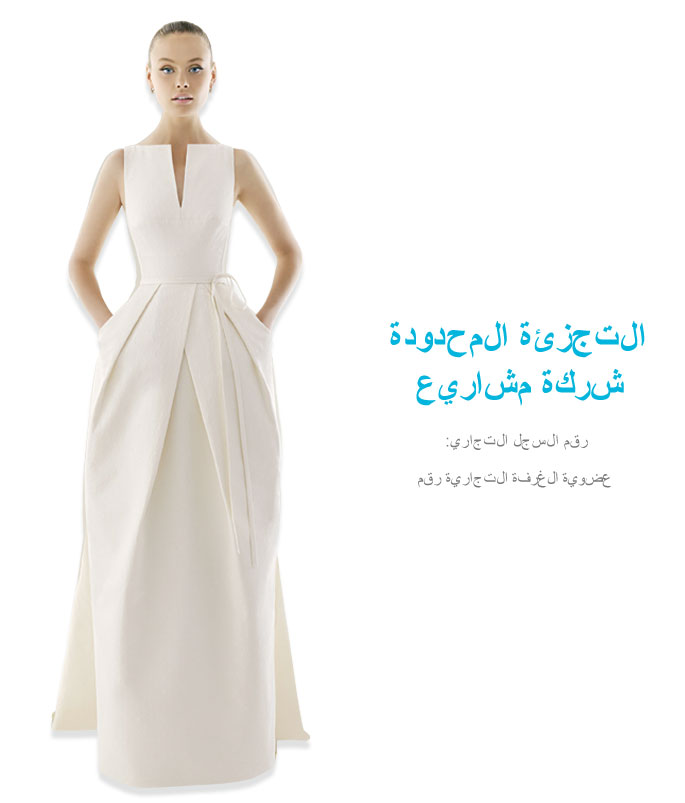 Eine Frau steht da und trägt ein ärmelloses, weißes, bodenlanges Kleid mit Taschen, Falten und einem dezenten V-Ausschnitt. Zu ihrer Rechten verweisen blauer arabischer Text und kleinerer grauer Text auf Vollblut Retail Projects.